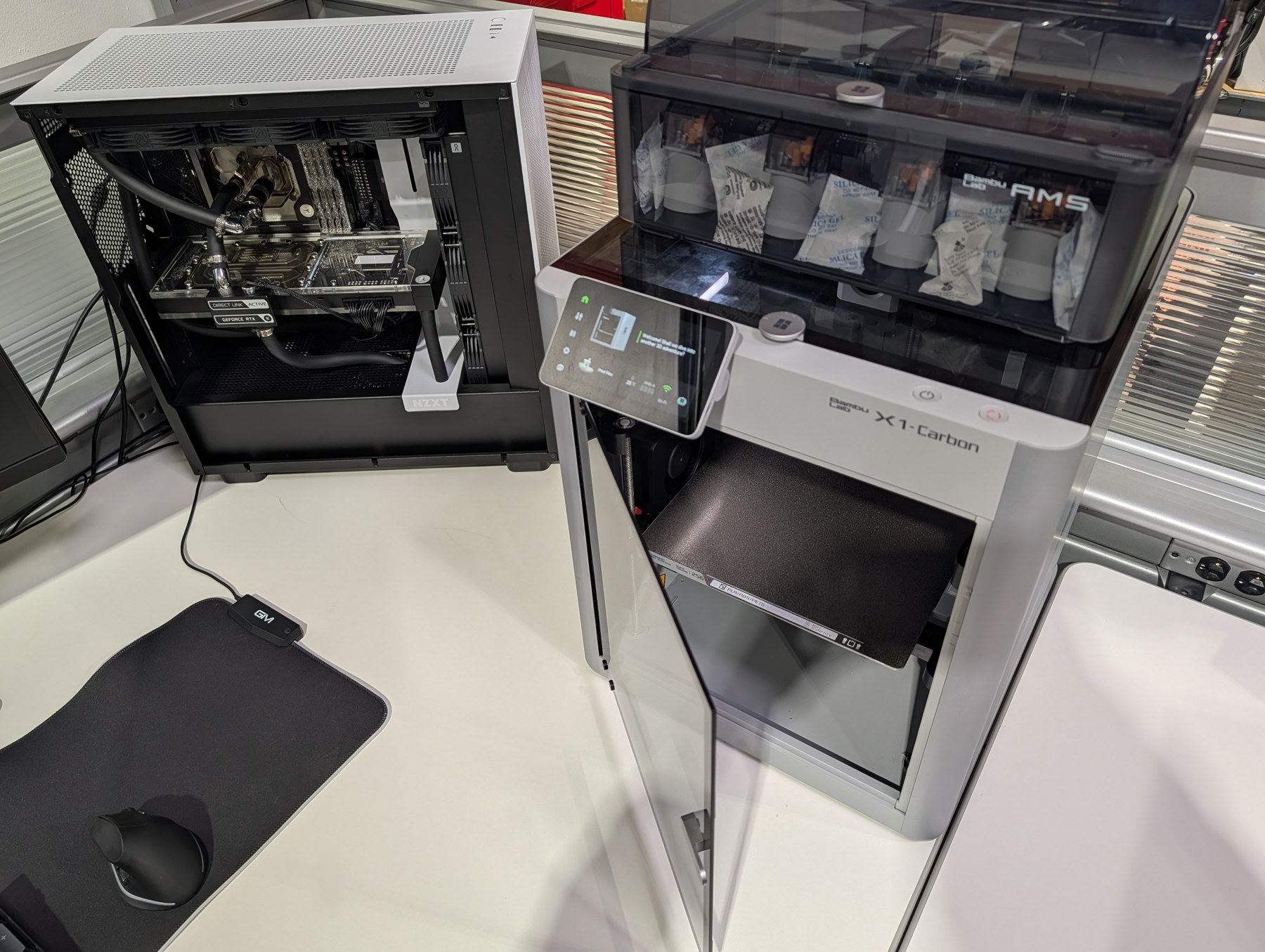 Meridian-built liquid-cooled workstation beside a Bambu Lab X1 Carbon and AMS